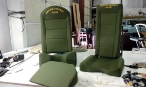 Aircraft seats in green with custom lettering in yellow