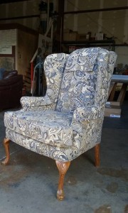 Classic sitting chair with wooden legs recovered in grey and blue pattern material