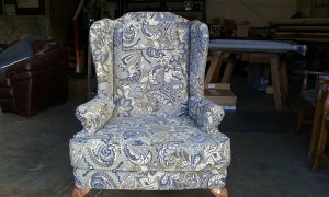 Classic sitting chair with wooden legs recovered in grey and blue pattern material